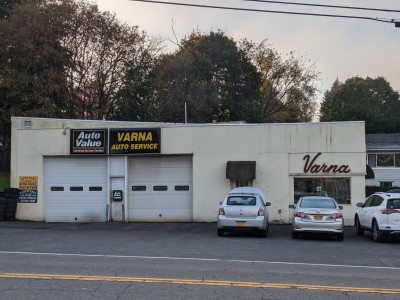 Front view of Varna Auto Service with garage doors and parked cars